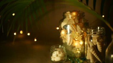 Cam kavanoz ev dekorasyonu için tropikal kabukları. Plaj temalı iç dekorasyon için deniz tarzı ev aksesuarları.