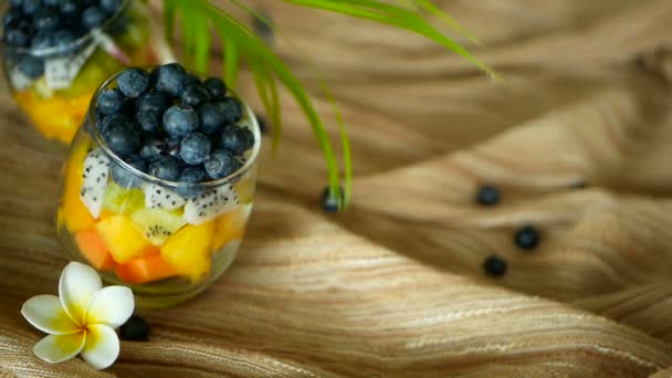 Färgglada tropiska blanda sallad i burk. Färsk olika slags raw ekologiska bär och frukt i glasskål. Hälsosam vegetarisk — Stockvideo