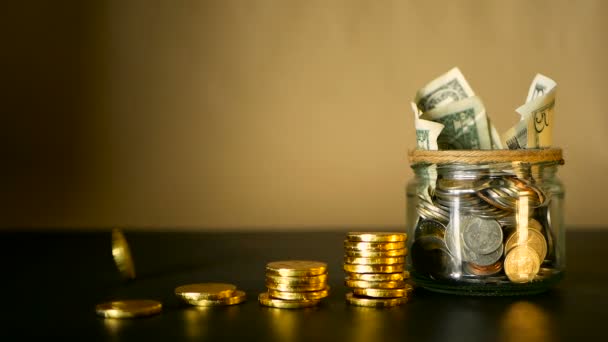 Saving money coin in jar. Symbol of investing, keeping money concept. Collecting cash banknotes in glass tin as moneybox — Stock Video