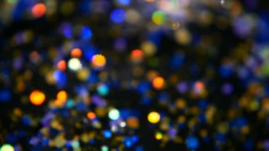 Ufuk parıldayan çok renkli glitter konfeti, siyah arka plan. Tatil soyut şenlikli bokeh Hafif lekeler.