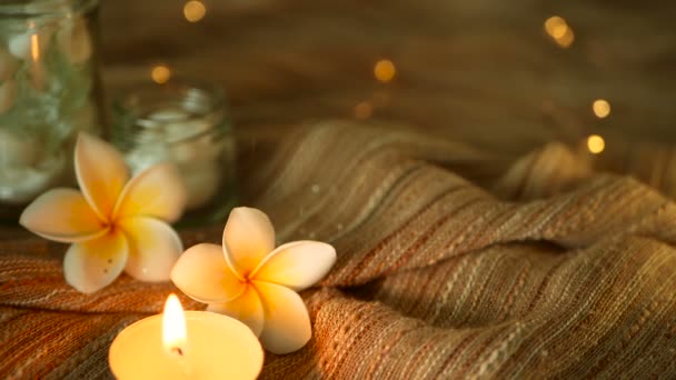 Vaso di vetro pieno di conchiglie, coralli, oggetti marini con luci a candela, fiori di plumeria frangipani per arredamento — Video Stock