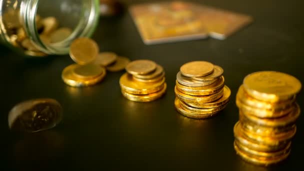 Símbolo de investir, manter o conceito de dinheiro. Close-up ainda vida com colunas crescentes de moedas de ouro na mesa preta — Vídeo de Stock