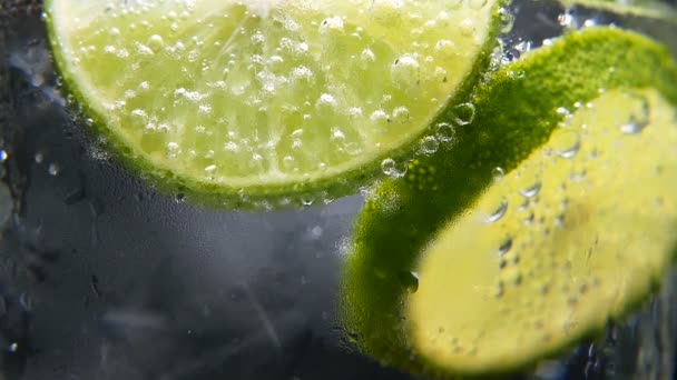 Concept de désintoxication ou soif. Alimentation saine et diététique. Citronnade froide, boisson au citron vert. Fond noir — Video