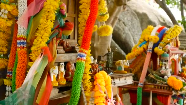 Miniatur-Wächterhaus aus Holz. kleiner buddhistischer Tempelschrein, bunte Blumengirlanden. san phra phum. — Stockvideo