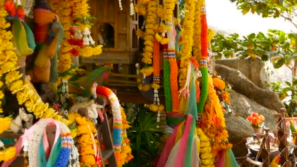 Wooden miniature guardian spirit house. Small buddhist temple shrine, colorful flower garlands. San phra phum. — Stock Video