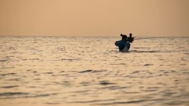 САМУИ, ТАЙЛАНД - 23 ИЮНЯ, 2018: Силуэт рыбака в действии при вращении, время захода солнца. Традиционная азиатская оккупация — стоковое видео