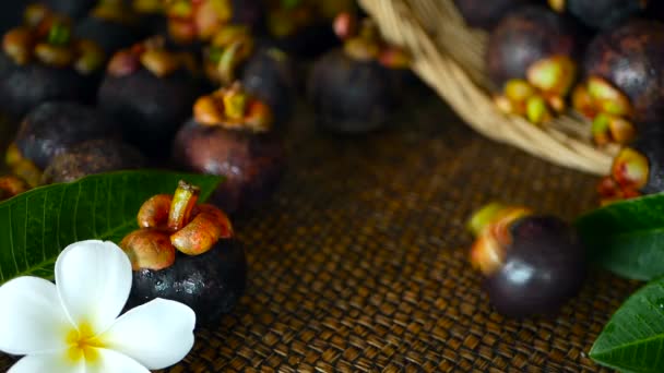 Вид сверху на свежие вкусные мангостаны на деревянном столе. Тайские органические фиолетовые фрукты в корзине . — стоковое видео