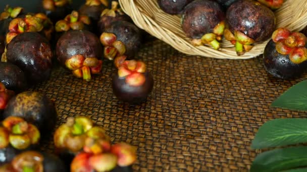 Vista superior de deliciosos mangostões colhidos frescos na mesa de madeira. Fruta roxa orgânica tailandesa na cesta . — Vídeo de Stock