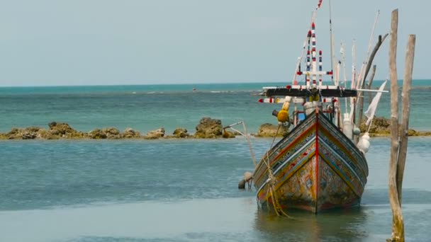 Tropical ocean beach, moored wooden traditional colorful fishing boat. Seascape near asian poor Muslim fisherman village — Stock Video