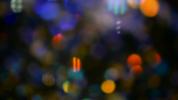 Defocused shimmering multicolored glitter confetti, black background. Holiday abstract festive bokeh light spots. — Stock Video