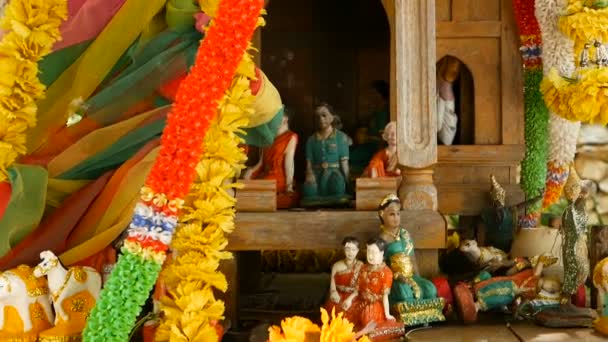 Trä miniatyr guardian ande hus. Liten buddhistiska templet altare, färgglada blomstergirlanger. San phra phum. — Stockvideo