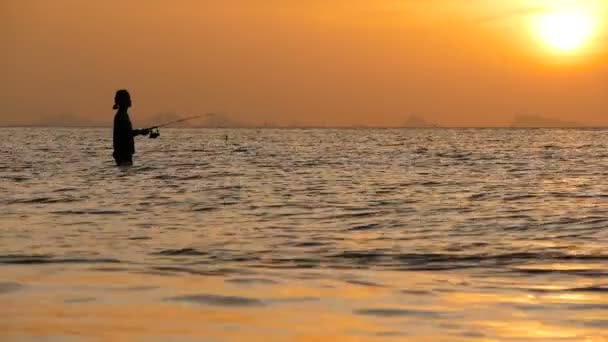 Sílhueta de pescador em ação ao girar na hora do pôr do sol. Ocupação tradicional asiática e maneira de obter alimentos — Vídeo de Stock