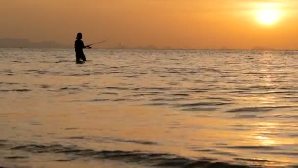 Fischer-Silhouette in Aktion, wenn sie sich bei Sonnenuntergang dreht. Traditionelle asiatische Beschäftigung und Art und Weise, Nahrungsmittel zu erhalten — Stockvideo