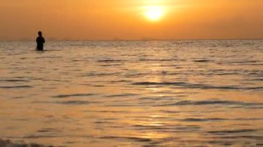 Gün batımında dönen balıkçı silueti. Geleneksel Asya işgali ve yiyecek edinme yöntemi