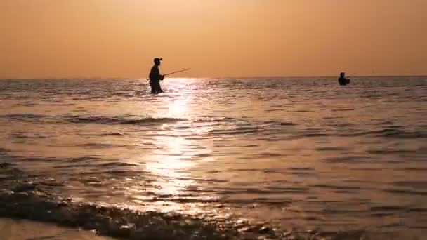 Силуэт рыбака в действии при вращении на закате. Традиционная азиатская оккупация и способ получения пищи — стоковое видео