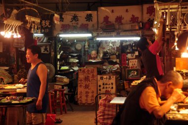 Hong Kong - 21 Şubat, 2015: levha ve lamba ışığında insanlar üzerinde hiyeroglifler ile karanlık oryantal jade pazarı görünümü, parlayan. Çinli satıcıların takı Hediyelik eşya.
