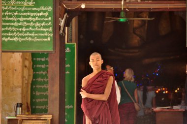 Bagan, Myanmar - 13 Kasım 2015: Etnik keşiş portre. Asya genç rahip tapınak girişi önünde duran elbise içinde. Mingalazedi pagoda. Sulamani Shwezigon Ananda Htilominlo
