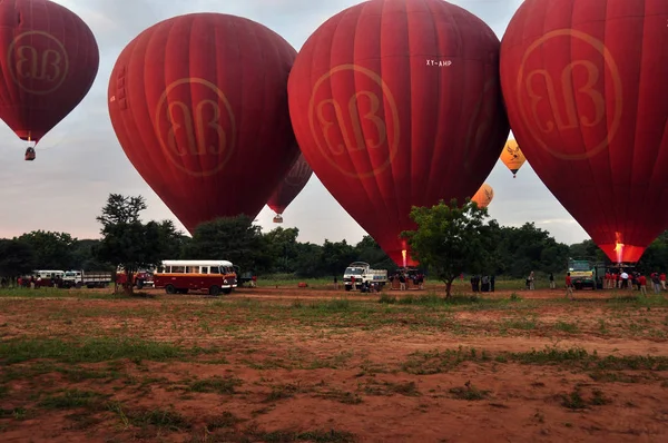 バガン ミャンマー 2015 明るい赤い気球広々 とした地形の地に赤い気球のたくさんのビューのフィールドに Mingalazedi スラマニあるシュエタリャン アナンダ ナンダウンミャー上空を飛ぶ — ストック写真