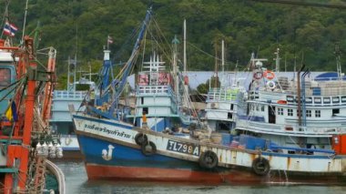 KANOM, THAILAND - 21 Eylül 2018. Kıyıdaki paslı botlar. Balıkçı şehrinde limana park edilmiş eski paslı gemiler. Balıkçı mürekkep balığı endüstrisi. Geleneksel Asya. Deniz kaynaklarının yok edilmesi kavramı.