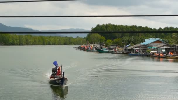 KHANOM, THAILAND - SEPTEMBER 21, 2018.渔民村的小船在红树林的河水上。传统的亚洲景观。穷困潦倒的房子。渔船 — 图库视频影像