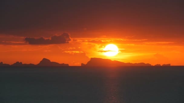 Majestoso verão laranja tropical timelapse pôr do sol sobre o mar com silhuetas montanhas. Vista aérea do crepúsculo dramático, céu nebuloso dourado sobre ilhas no oceano. Vivid entardecer paisagem marinha fundo natural — Vídeo de Stock