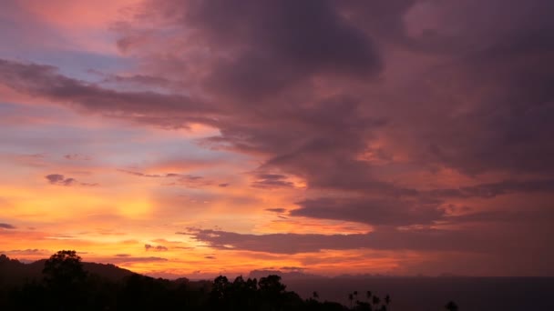 Величественный тропический оранжевый летний временной закат над морем с силуэтами гор. Воздушный вид драматических сумерек, золотистого облачного неба над островами в океане. Яркий закат морской пейзаж — стоковое видео