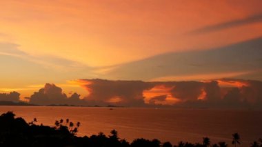 Görkemli tropikal turuncu yaz timelapse günbatımı dağlar siluetleri ile deniz üzerinde. Okyanusu Adaları üzerinde dramatik alacakaranlık, altın bulutlu gökyüzü hava görünümünü. Alacakaranlıkta canlı deniz manzarası doğal arka plan