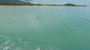 Sandy beach küçük geleneksel Tay tarzında kulübe ve sakin okyanus, Koh Samui Adası, Tayland ile. Yeşil Hindistan cevizi avuç içi kıyı ve dağ arkasında. Pastoral tropikal egzotik cennet waterscape,