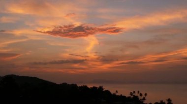 Görkemli tropikal turuncu yaz timelapse günbatımı dağlar siluetleri ile deniz üzerinde. Okyanusu Adaları üzerinde dramatik alacakaranlık, altın bulutlu gökyüzü hava görünümünü. Alacakaranlıkta canlı deniz manzarası doğal arka plan