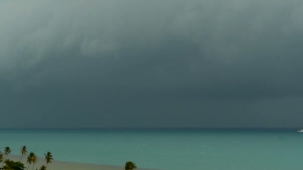 Δραματική ζοφερή ουρανό με σκούρο καταιγίδα σύννεφα πάνω από τα τυρκουάζ νερά της θάλασσας. Τυφώνας στο ορίζοντας του ωκεανού. Ζωηρά εναέρια timelapse όμορφη θέα θύελλα βρέχει Θαλασσογραφία. Τροπική βροχή εποχή τυφώνα καιρικές — Αρχείο Βίντεο