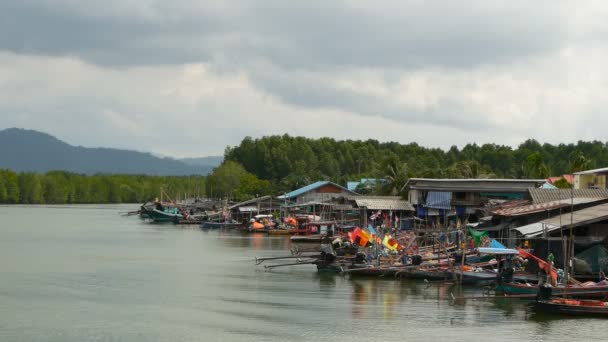 KHANOM, THAILAND - 21 сентября 2018 года. Маленькие лодки в рыбацкой деревне на воде реки в мангровых зарослях. Традиционный азиатский пейзаж. Бедные дома на ходулях. Рыболовные суда — стоковое видео