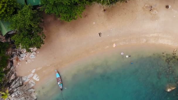 Drone Drone Draufsicht auf weißen Sand tropischen exotischen Paradies winzigen Küste in Koh Prangan Insel, Thailand. kleine Boote auf der Meeresoberfläche. Netter abgelegener Strand mit vulkanischen Steinen und grünen Kokospalmen — Stockvideo