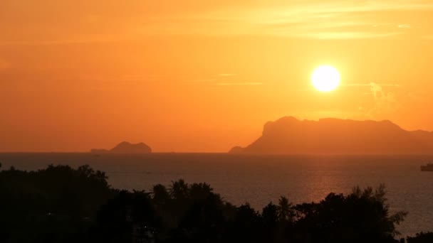 山のシルエットと海の上雄大な熱帯オレンジ夏タイムラプス夕日。劇的なミステリー、黄金曇り海の島上空の空撮。鮮やかな夕暮れの海自然な背景 — ストック動画