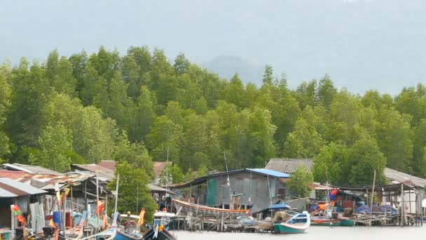 KHANOM, THAILAND - SETEMBRO 21, 2018. Pequenos barcos na aldeia de pescador em água de rio em manguezais. Paisagem tradicional da Ásia. Casas pobres em palafitas. Embarcações — Vídeo de Stock
