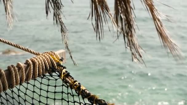 Närbild av romantiska mysiga Tom Hängmatta med tropiska havet i bakgrunden. Semester till paradise, resa till havet, semester i exotisk strandresort, idylliska avkoppling lat tid koncept — Stockvideo