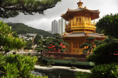 Güzel oryantal bahçe şehir, altın oryantal kule ile yeşil Nan Lian bahçesinde cityscape bulunan kırmızı köprü görünümünü arka planda, Hong Kong