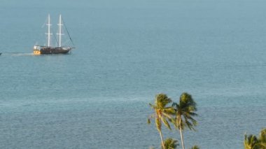 Yelkenli tekne ve tropikal egzotik bitkiler ile deniz. Yukarıdan görünüm sakin mavi okyanusun yüzeyinde yüzen ahşap gemi ile kıyı avuç içi ile kaplı. Koh Samui Adası Tayland resort. Seyahat kavramı
