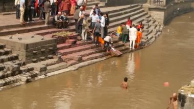KATHMANDU, NEPAL - 8 Ekim 2018: Yerel Hindu halkı, Pashupatinath tapınağındaki kutsal Bagmati Nehri kıyısındaki yanan ghatlarda geleneksel yakma töreni