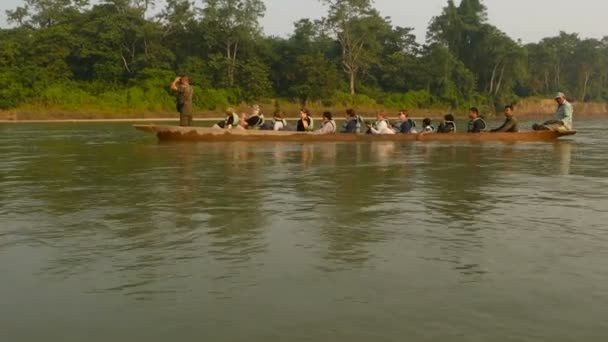 奇旺国家公园（英语：CHITWAN National PARK, NEPAL）- 2018年10月10日，乘坐独木舟在河上航行的游客。游览时，游客乘坐的长木独木舟在碧绿的河里漂流. — 图库视频影像