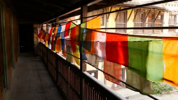 Peças de tecido coloridas no terraço da casa. Vista perspectiva de cordas com tecidos coloridos com orações penduradas acima da cerca de terraço ao ar livre . — Vídeo de Stock