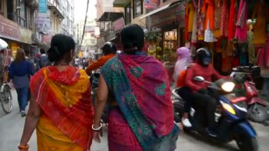 KATHMANDU, NEPAL - 8 EKİM 2018 Sokakta yürüyen renkli ulusal giysili kadınlar. Etnik kadınların parlak ulusal elbiseler giydiği Hint sarisi. Asan Pazarı.