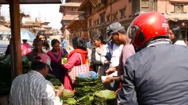 LALITPUR, NEPAL - 7 OCTOBER 2018 Люди, що оточують зал і купують невеликі ритуальні тарілки для ритуалів на королівській площі Дурбар, Катманду. Щоденне життя, стародавнє східне місто — стокове відео