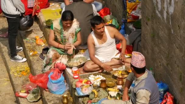 Kathmandu, Nepal - 8 oktober 2018 Madeleine att göra ritualer sörjer de döda, be med brahman. Tonsuren hinduiska traditionella anpassad. Puja i Pashupatinath-templet. Heliga män på de ghats välsignelse relativa — Stockvideo