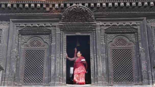 BHAKTAPUR, KATHMANDU, NEPAL - 18. října 2018 Noví lidé navštěvují hinduistický chrám za účelem uctívání v tradičních šatech. Náboženský každodenní život občanů, orientální starobylé město po zemětřesení — Stock video