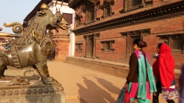 BHAKTAPUR, KATHMANDU, NEPAL - 18 de outubro de 2018 Tráfego diário de pedestres na antiga cidade oriental após o terremoto. Newar local pessoas em roupas nacionais indo nas ruas perto do templo — Vídeo de Stock