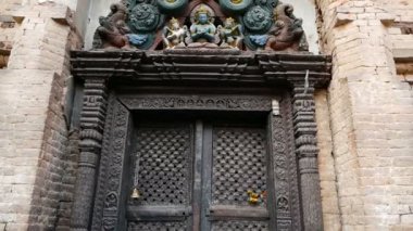 Süs tasarım, tapınak giriş. Eski renkli ahşap kapı yukarıda Tanrı heykeli ile yaşlı giriş aşağıdan. Katmandu Vadisi, Swayambhunath Stupa, maymun Tapınağı, Nepal. Shantipura Mahavihar.