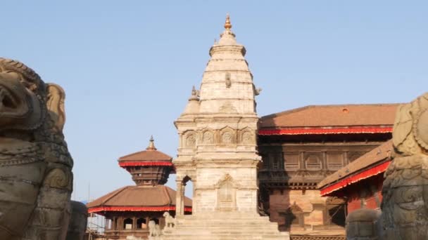 Vacker gammal arkitektur av royal Durbar square. Exteriör av tempelbyggnader på Durbar square i starkt solljus under blå himmel. orientaliska antika staden efter jordbävningen — Stockvideo