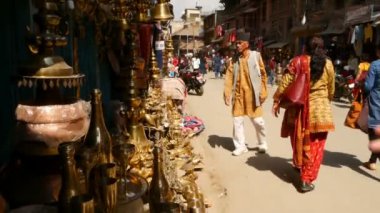 LALITPUR, NEPAL - 7 Ekim 2018 Patan Caddesi 'ndeki yerel pazar. Küçük dükkanlarla dar sokaklarda yürüyen insanlar çeşitli bronz ve pirinç eşyalar satıyorlar, Katmandu..
