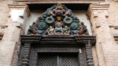 Süs tasarım, tapınak giriş. Eski renkli ahşap kapı yukarıda Tanrı heykeli ile yaşlı giriş aşağıdan. Katmandu Vadisi, Swayambhunath Stupa, maymun Tapınağı, Nepal. Shantipura Mahavihar.