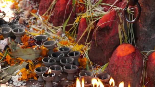 Helgedom med skulptur och ljus brinnande. Hinduiskt tempel helgedom utomhus med skulptur av Ganesha och brinnande ljus i solljus, Nepal. — Stockvideo